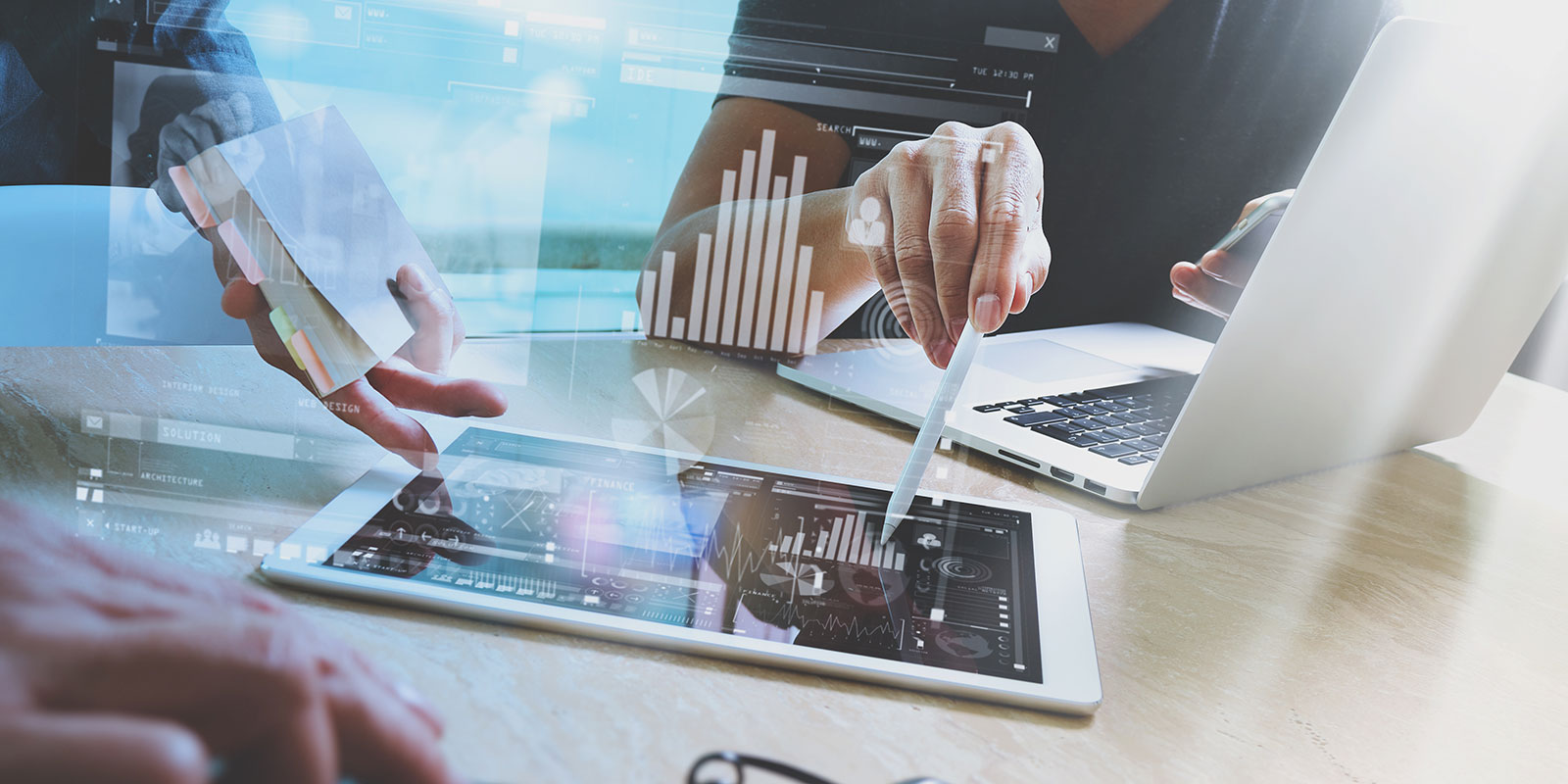 Slide 1 - Market, people discussing options over tablet at desk with laptop open.